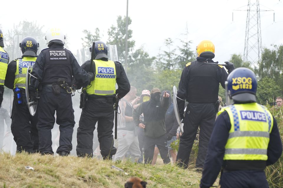 Scott Greenwood (centre, with yellow face covering and bucket hat) was at the forefront of a group confronting riot police (Danny Lawson/PA).