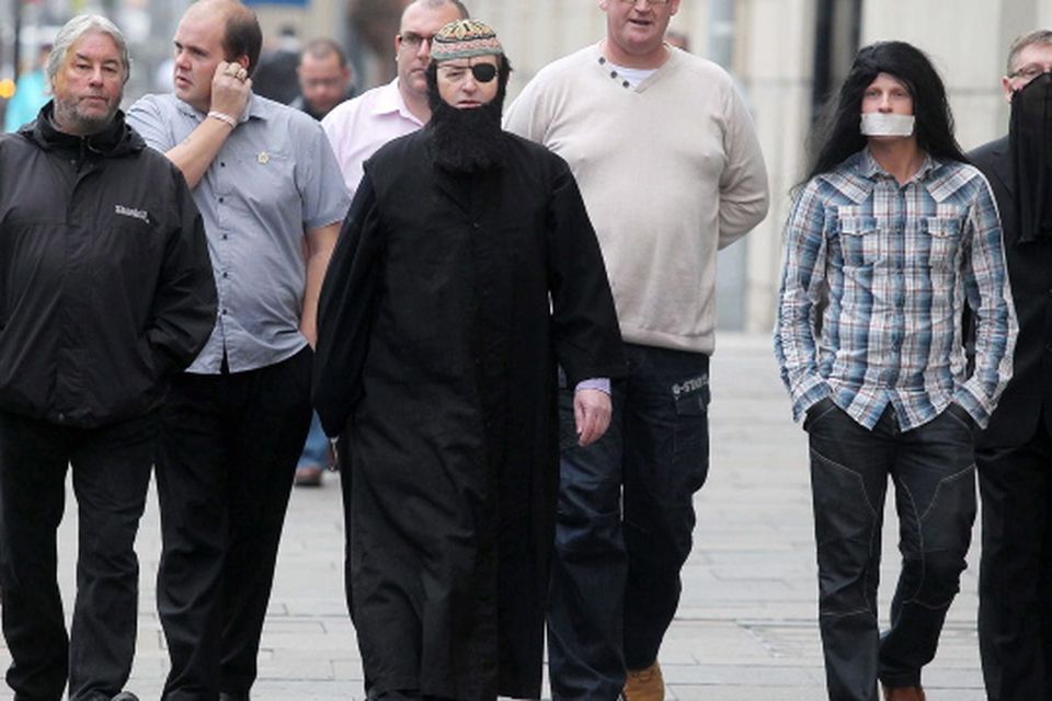 Loyalist campaigner Willie Frazer appears at Belfast Laganiside Courts in relation to his flag protest charges dressed as Muslim Cleric Abu Hamza.  Willie Frazer arrives at court with his supporters including Jim Dawson (right) and Jamie Bryson (second from right)