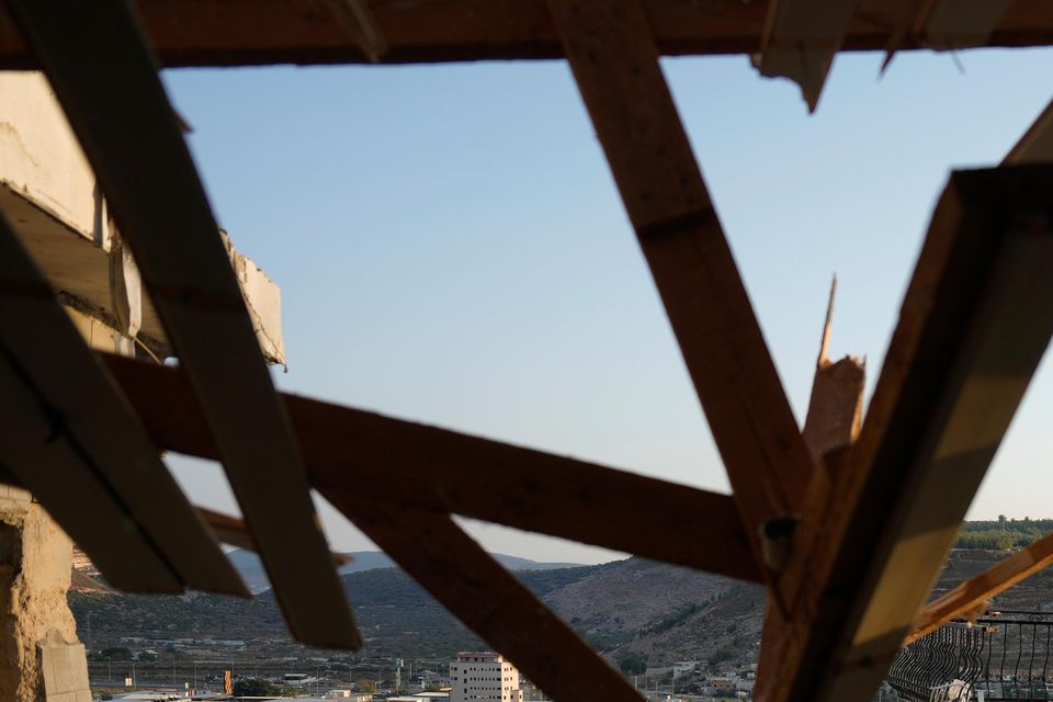 Israeli security forces survey damage to a home in the north of the country which was struck by a rocket fired from Lebanon (Ariel Schalit/AP)