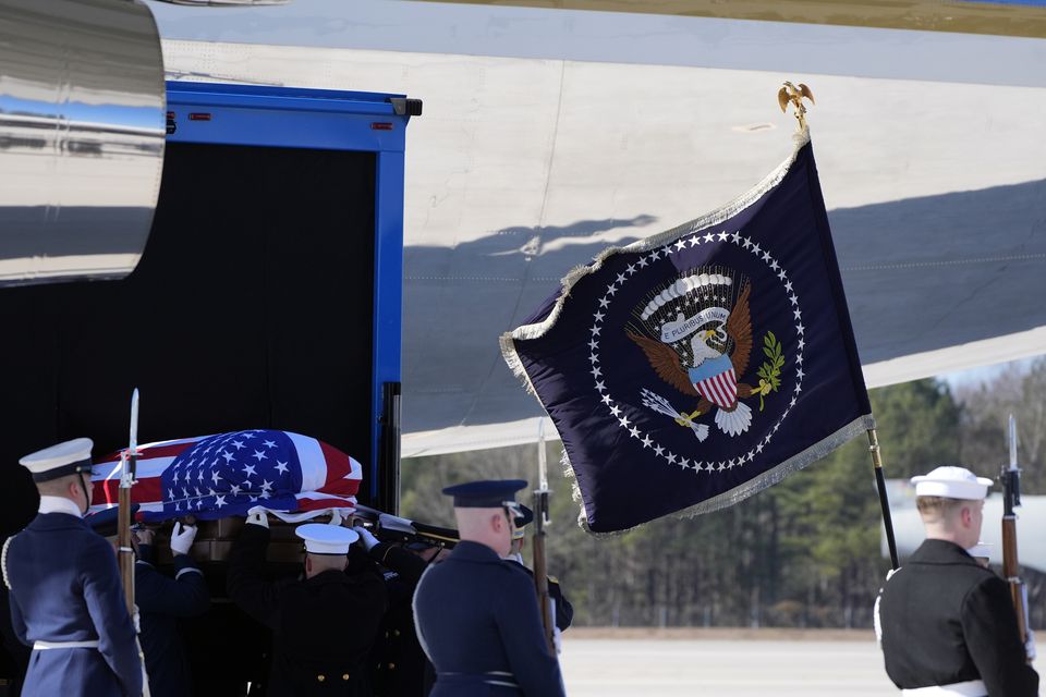 The flag-draped casket of former president Jimmy Carter is placed onto Special Air Mission 39 at Dobbins Air Reserve Base in Marietta, Georgia (Alex Brandon/AP)