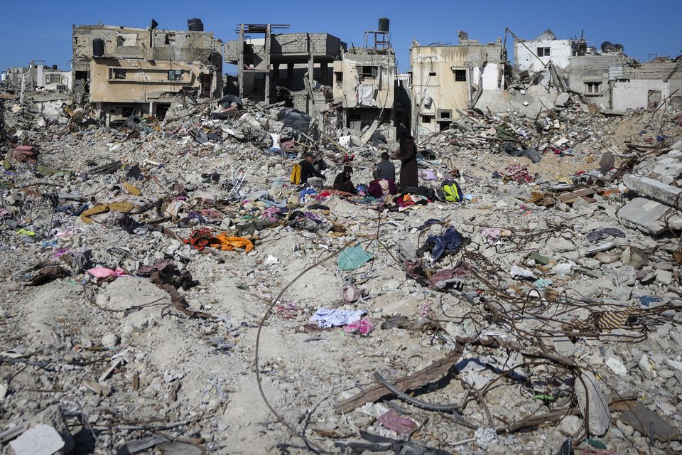 Palestinians search for their belongings under the rubble of destroyed homes in Rafah (Abdel Kareem Hana/AP)