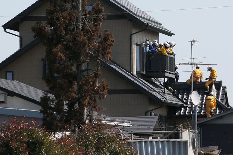 SENDAI, JAPAN - MARCH 14:  Members of a rescue team climb into a house after a warning of tsunami is issued after a 9.0 magnitude strong earthquake struck on March 11 off the coast of north-eastern Japan, on March 14, 2011 in Sendai, Japan. The quake struck offshore at 2:46pm local time, triggering a tsunami wave of up to 10 metres which engulfed large parts of north-eastern Japan. The death toll is currently unknown, with fears that the current hundreds dead may well run into thousands.  (Photo by Kiyoshi Ota/Getty Images)