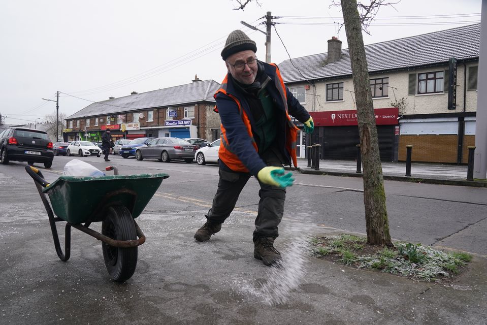 Park Services workers from Dublin City Council gritting footpaths in Ballygall in Dublin ahead of a Status Orange low temperature warning issued for most counties on Wednesday night (Brian Lawless/PA)