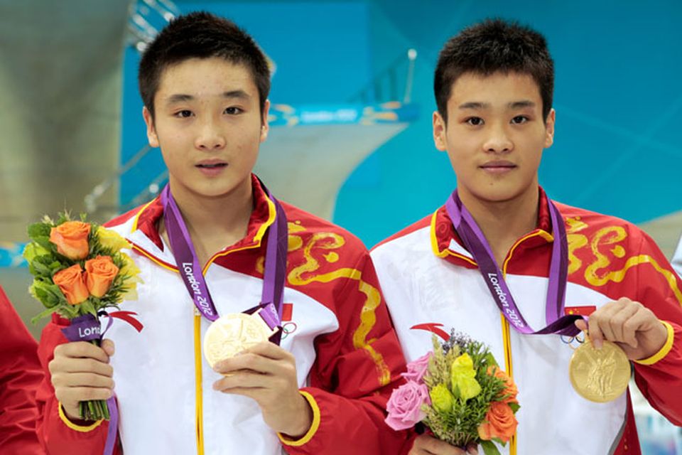 LONDON, ENGLAND - JULY 30:  (L-R) Yuan Cao and Yanquan Zhang of China celebrate with their gold medals during the medal cermony for the Men's Synchronised 10m Platform Diving on Day 3 of the London 2012 Olympic Games at the Aquatics Centre on July 30, 2012 in London, England.  (Photo by Adam Pretty/Getty Images)