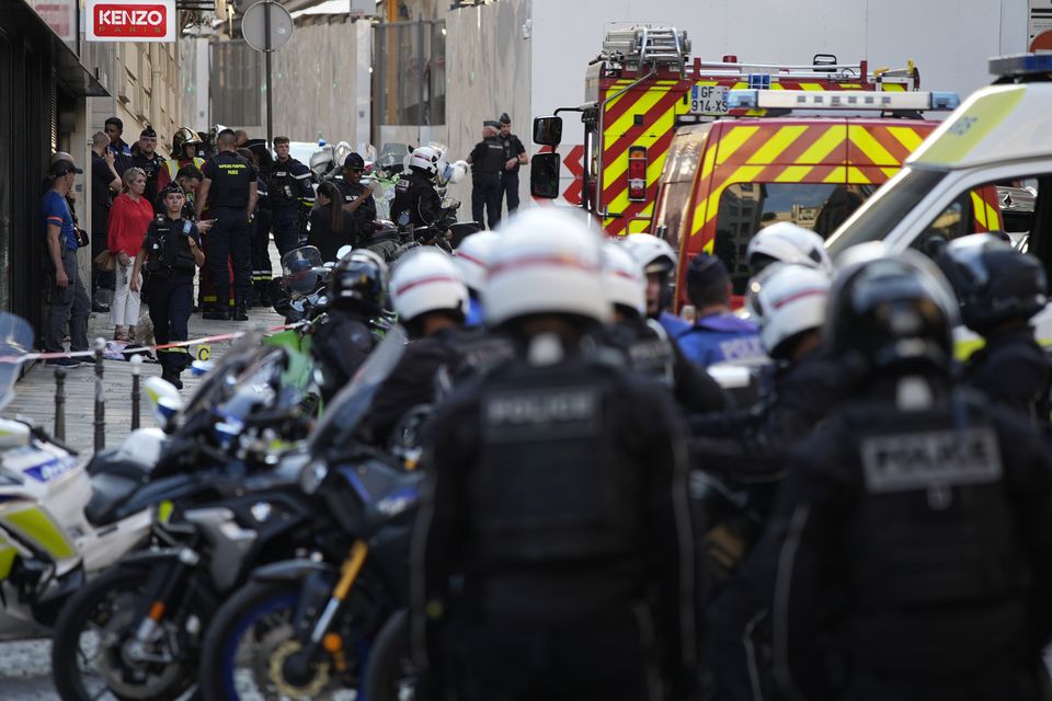 Police officers and rescue workers gather near the Champs-Elysees (David Goldman/AP)