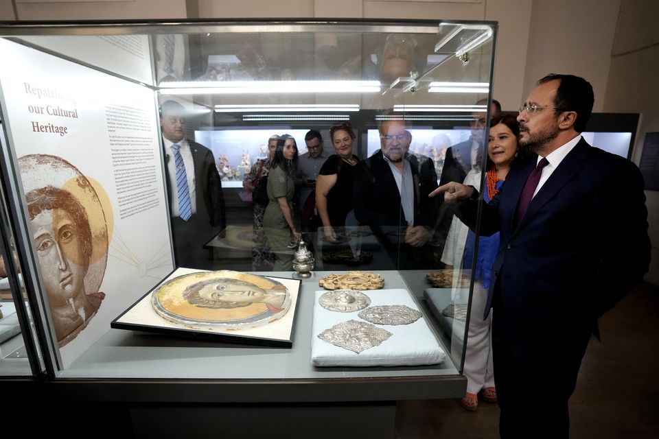 President Nikos Christodoulides studies an Orthodox Christian icon (Petros Karadjias/AP)