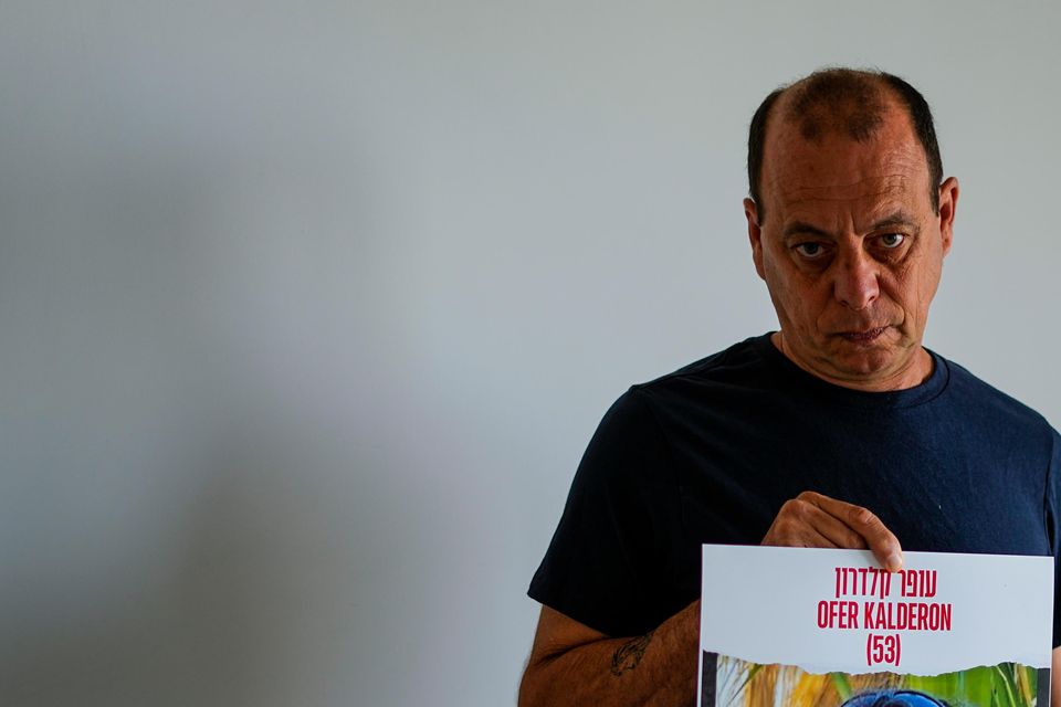 Nissan Kalderon poses in Ramat Gan, Israel, with a photo of his only brother, Ofer Kalderon (Ariel Schalit/AP)