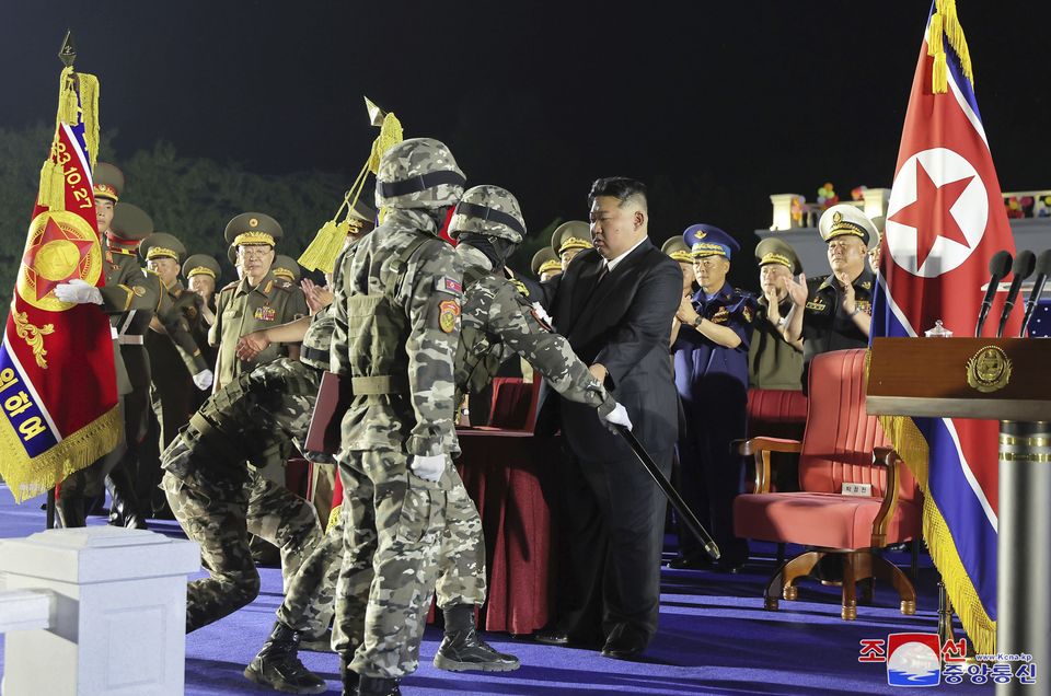 North Korean leader Kim Jong Un hands its military flag to soldiers. (Korean Central News Agency/Korea News Service via AP)