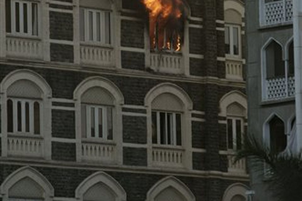 Flames come from a room of the Taj Mahal hotel in Mumbai, India, Thursday, Nov. 27, 2008. Black-clad Indian commandoes raided two luxury hotels to try to free hostages Thursday, and explosions and gunshots shook India's financial capital a day after suspected Muslim militants killed people. (AP Photo/Gurinder Osan)