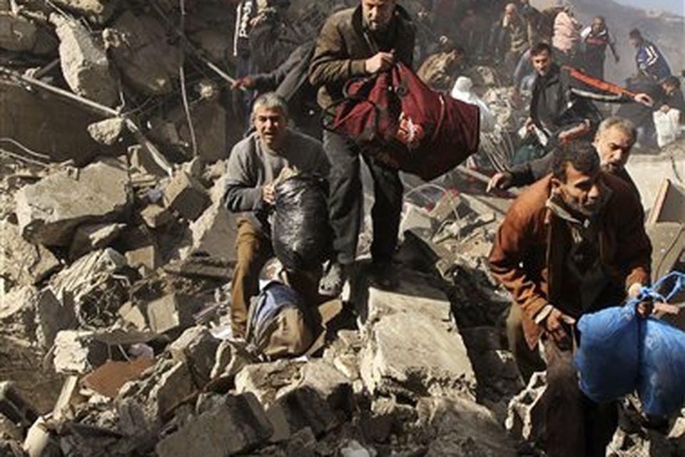 Palestinian prisoners flee over the rubble of the central security headquarters and prison, known as the Saraya, after it was hit during an Israeli missile strike, in Gaza City, Sunday, Dec. 28, 2008. Some 280 Palestinians have been killed and 600 people wounded since Israel's campaign to quash rocket barrages from Gaza began midday Saturday, a Gaza health official said. Most of the dead were Hamas police. (AP Photo/Adel Hana)