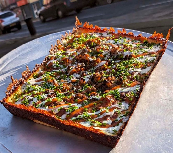 The Detroit style sourdough pizza, made with their own buffalo sauce, cinnamon-spiced cauliflower, buttermilk ranch, parmigiano reggiano, and fresh chives