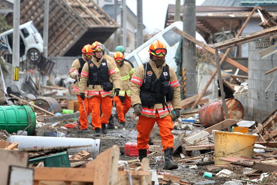 Members of a Korean rescue team walk through an area damaged by earthquake and tsunami after a 9.0 magnitude strong earthquake struck on March 11 off the coast of north-eastern Japan, on March 15, 2011 in Sendai, Japan. The quake struck offshore at 2:46pm local time, triggering a tsunami wave of up to 10 metres which engulfed large parts of north-eastern Japan. The death toll continues to rise with fears that the official death count could well reach up to 10,000 in "the most tragic event in Japanese history since World War Two".