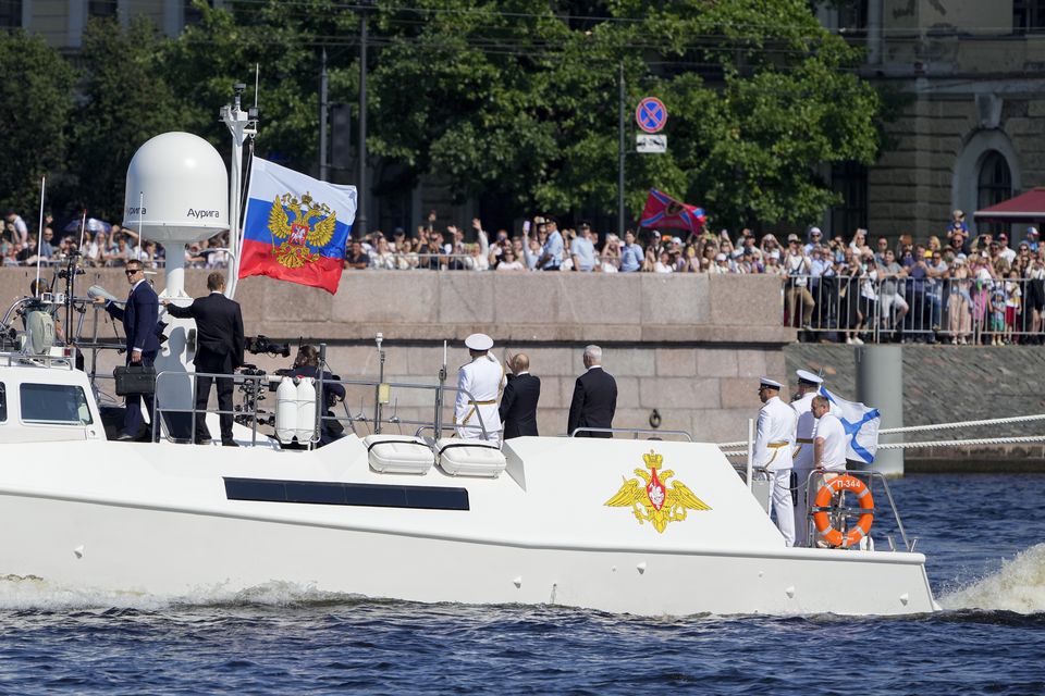 President Vladimir Putin and Russian officials wave to spectators during Navy Day in St Petersburg (Dmitri Lovetsky/Pool/AP)