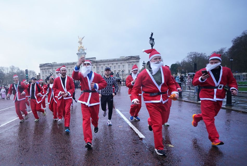 People brave the weather to take part in the Scrambled Legs Running Club 10k Santa Run in central London (Yui Mok/PA)