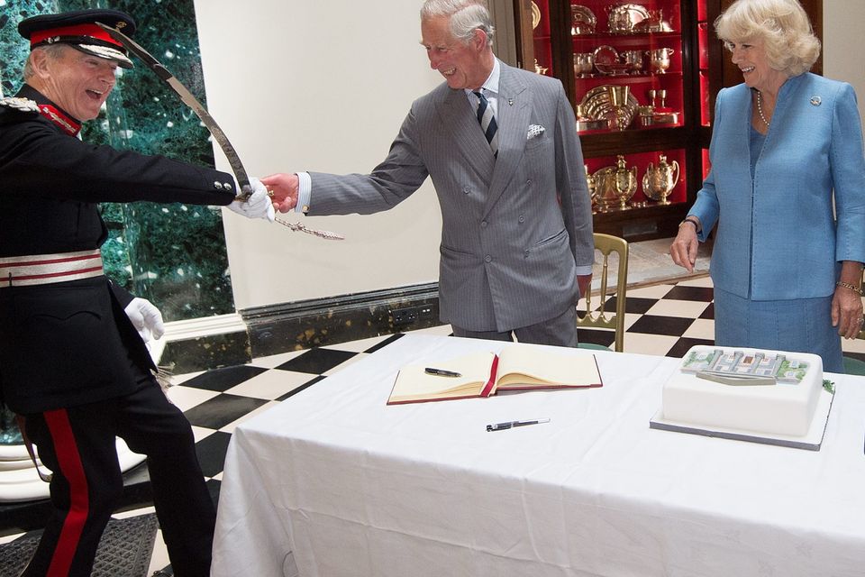 ANTRIM, NORTHERN IRELAND - MAY 22:  Prince Charles, Prince of Wales and Camilla, Duchess of Cornwall cut a cake with the help of Mr David Lindsay, HM Lord-Lieutenant of County Down during their visit to Mount Stewart House and Garden on May 22, 2015 in Newtownards, Northern Ireland. Prince Charles, Prince of Wales and Camilla, Duchess of Cornwall visited Mount Stewart House and Gardens and Northern Ireland's oldest peace and reconciliation centre Corrymeela on the final day of their visit of Ireland.  (Photo by Eddie Mulholland - Pool/Getty Images)