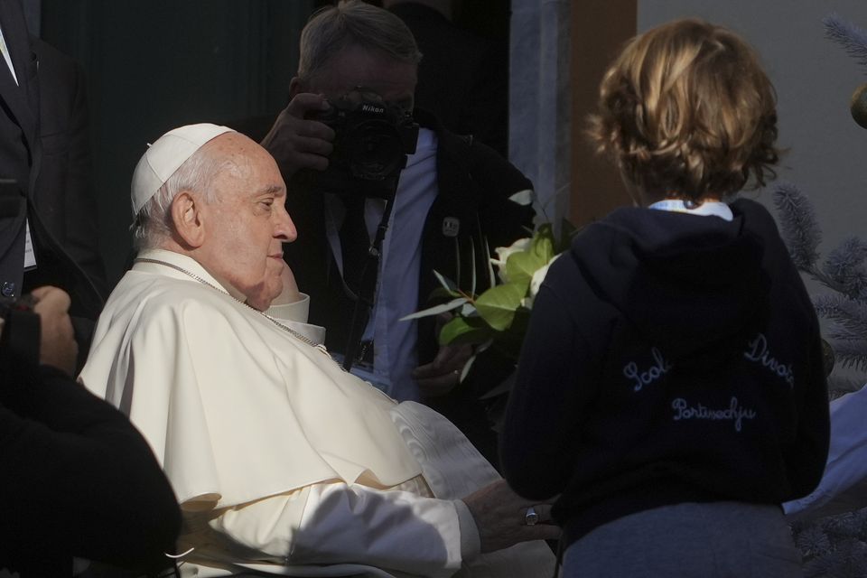 Pope Francis is presented with flowers by a child as he arrives outside the Cathedral of Our Lady of the Assumption (Alessandra Tarantino/AP)