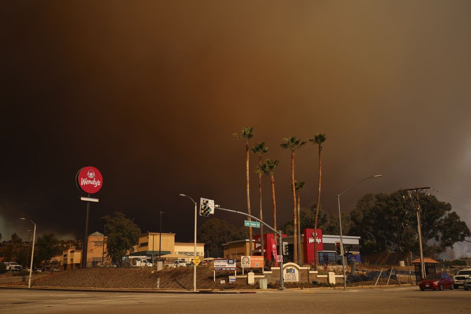 Smoke fills the sky during a wildfire in Castaic, California (Ethan Swope/AP)