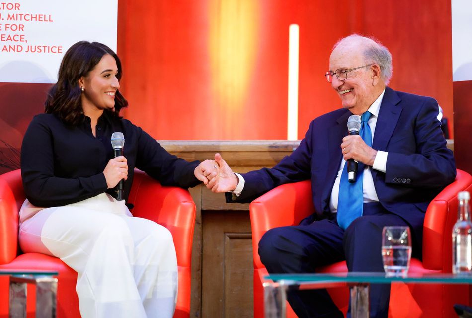 Erin McArdle holds hands with Senator George Mitchell at the Queen's University event this week