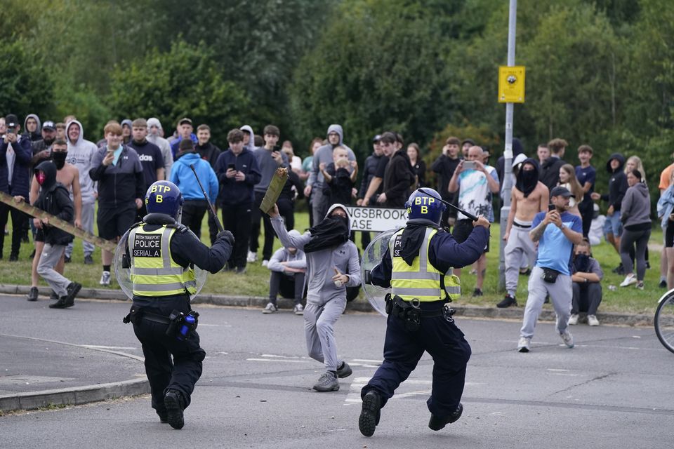 A youth aims a fence post towards police during an anti-immigration demonstration near the Holiday Inn Express in Rotherham, South Yorkshire, on Sunday August 4 (Danny Lawson/PA)