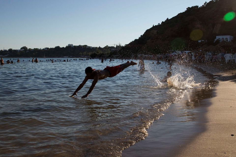 A man jumps into the water at a beach in Sidi Bou Said, on the outskirts of the capital Tunis, on July 1, 2015, a few days after a deadly attack on tourists in Port El Kantaoui by a jihadists gunman. Tunisia said it started deploying armed police around tourist sites after last week's massacre at a beach resort, as authorities finished identifying all 38 foreigners killed in the jihadist attack. AFP PHOTO / KENZO TRIBOUILLARDKENZO TRIBOUILLARD/AFP/Getty Images