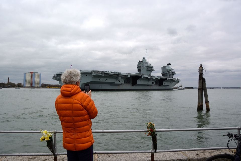 A member of the public watches as HMS Prince of Wales returns to Portsmouth Naval Base (Ben Mitchell/PA)