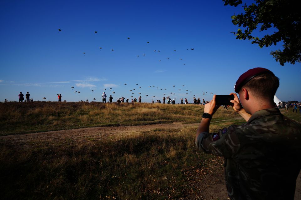 A member of the British armed forces takes a photo of paratroopers (Ben Birchall/PA)