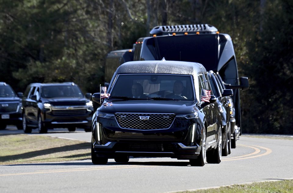 The motorcade with the hearse carrying the flag-draped coffin of former president Jimmy Carter arrives at the Jimmy Carter Boyhood Farm (Hyosub Shin/Atlanta Journal-Constitution/AP)