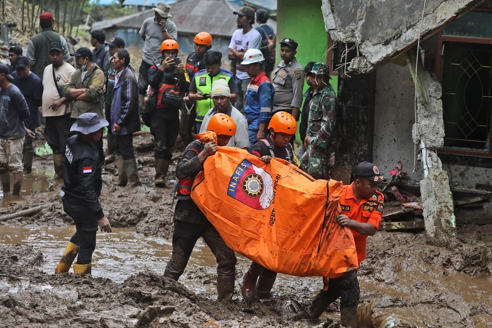 Rescuers carry the body of a victim of the landslide in Karo, North Sumatra, Indonesia (Binsar Bakkara/AP)