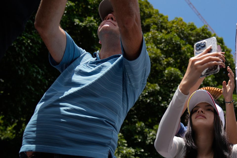 A woman holds up a vote tally sheet during the rally in Caracas (Ariana Cubillos/AP)