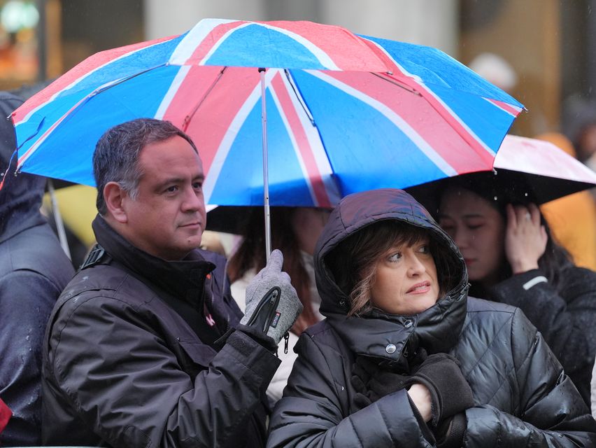 Rain falls as people gather to watch the New Year’s Day Parade in central London (Jonathan Brady/PA)