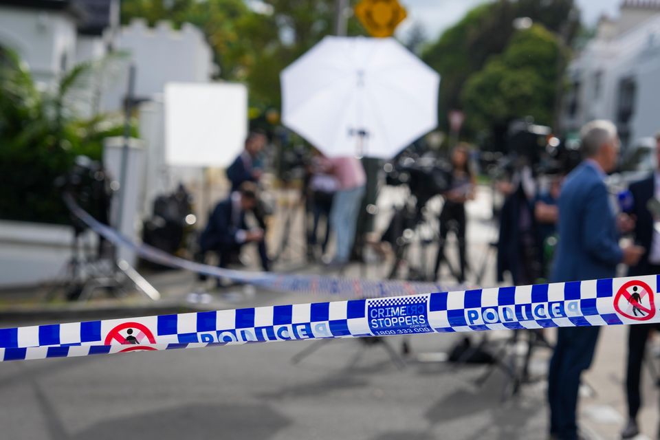 Media wait outside a police cordon at a street where houses were vandalised with anti-Israel slogans (Mark Baker/AP)