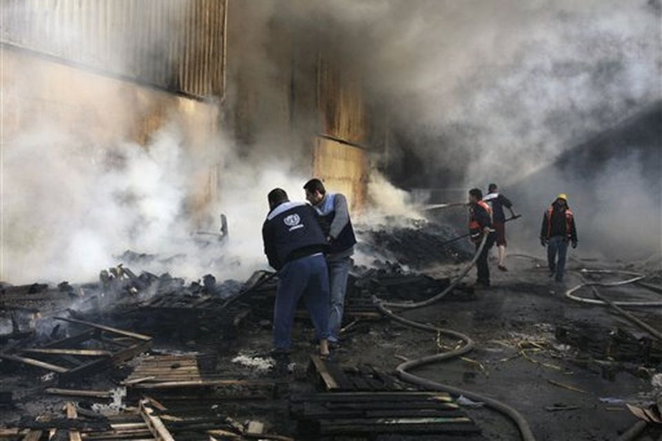 United Nations workers and Palestinian firefighters work to try and put out a fire and save bags of food aid at the United Nations headquarters after it was hit in Israeli bombardment in Gaza City, Thursday, Jan. 15, 2009. Israeli forces shelled the United Nations headquarters in the Gaza Strip on Thursday, setting the compound on fire as U.N. chief Ban Ki-moon was in the area on a mission to end Israel's devastating offensive against the territory's Hamas rulers. Ban expressed "outrage" over the incident.(AP Photo/Hatem Moussa)