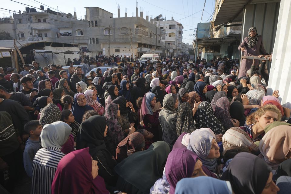 A crowd gathers in front of a bakery to get a share of bread in Deir al-Balah, Gaza Strip (Abdel Kareem Hana/AP)