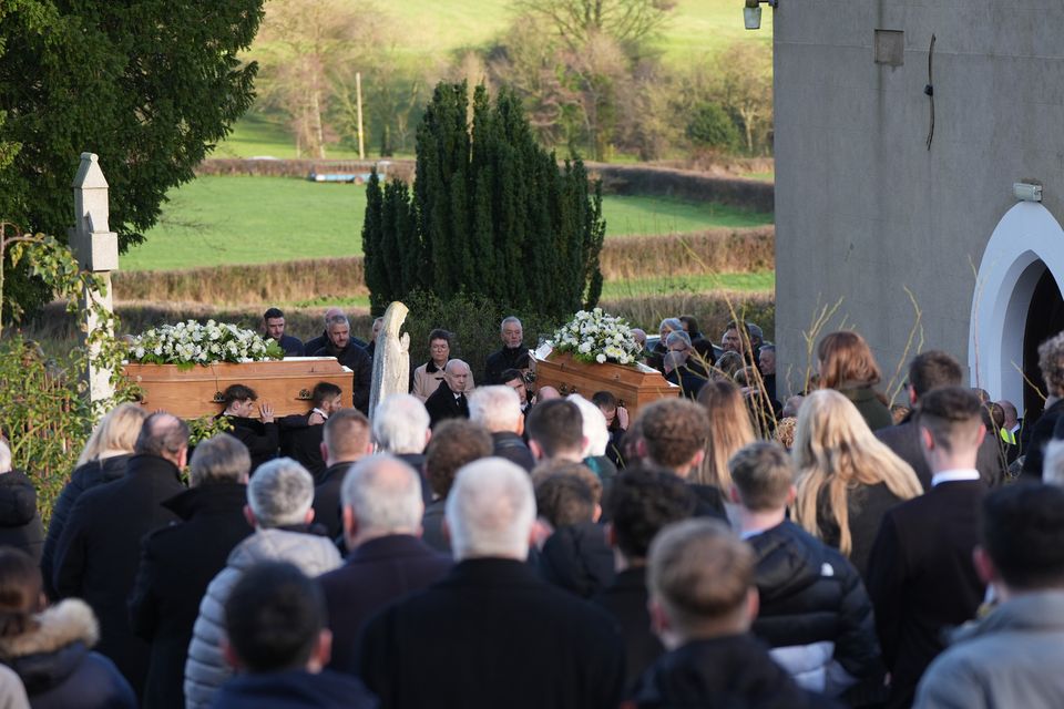 The coffins of father and son Peter and Loughlin Devlin being carried into the Church of St Joseph in Tynan for their funeral (Niall Carson/PA)