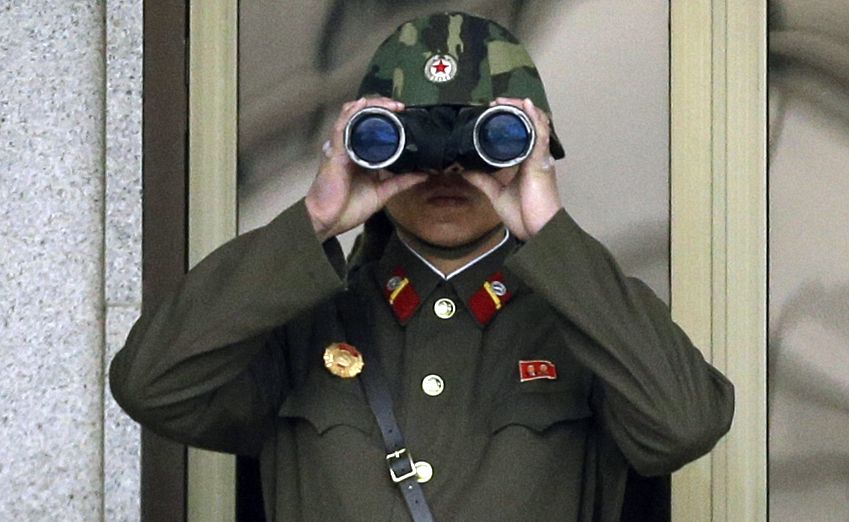 A North Korean soldier looks at the southern side through a pair of binoculars at the border village of Panmunjom (AP/Lee Jin-man)