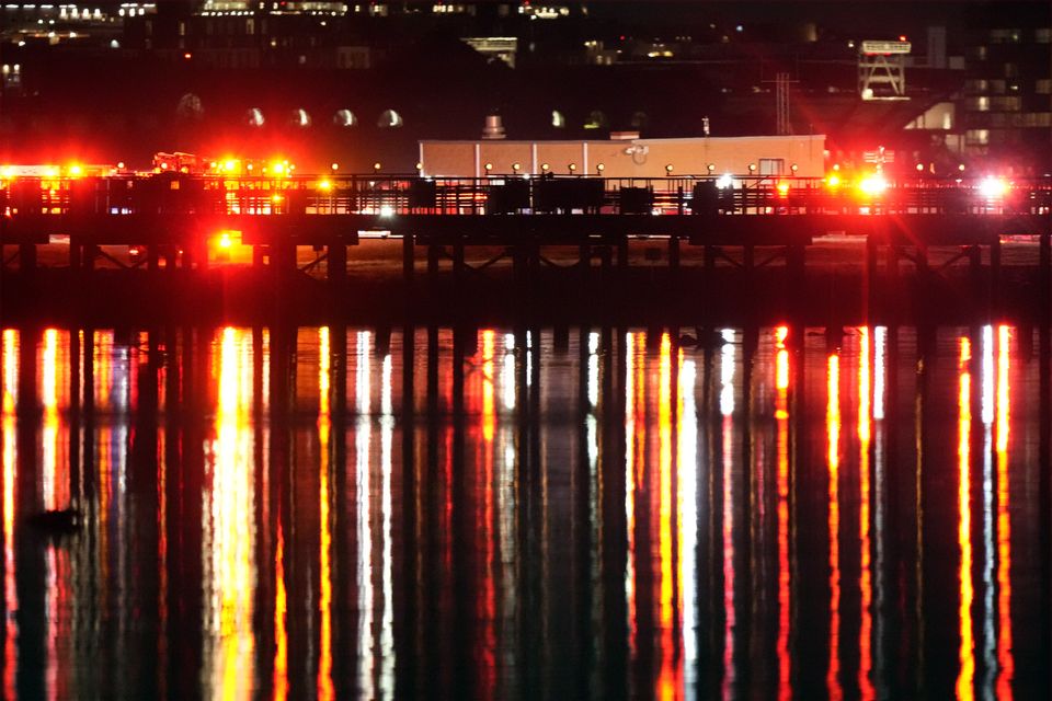 Emergency lights are reflected in the Potomac River near Ronald Reagan Washington National Airport (Alex Brandon/AP)