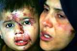 thumbnail: Samera  Baalusha (34) carries her surving child Mohamad (15 months) while she waits to see the body of her daughter Jawaher Baalusha (aged 4) during the funeral held for her and four of her sisters who were killed in an Israeli missile strike, on December 29, 2008 in the Jebaliya refugee camp, in the northern Gaza Strip. Jawher Baalusha and four of her sisters were killed during an Israeli air raid while they were sleeping together in their bedroom.