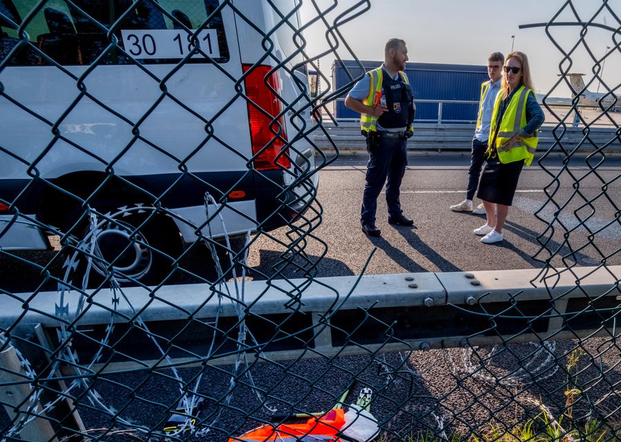 Police officers study the hole in the fence (Michael Probst/AP)