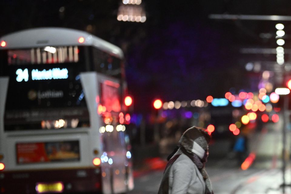 People on the near-deserted Princes Street in Edinburgh after all outdoor Hogmanay events were cancelled due to bad weather (Andy Buchanan/PA)