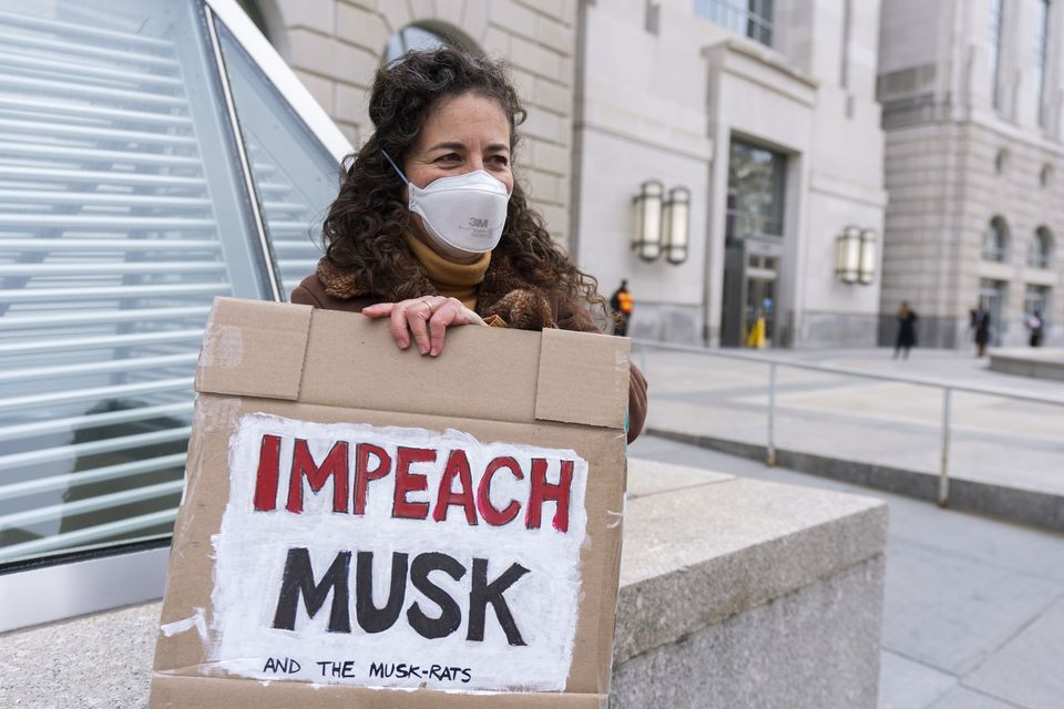 A United States Agency for International Development, or USAID contract worker with a placard protesting the cessation of USAID (Manuel Balce Ceneta/AP)