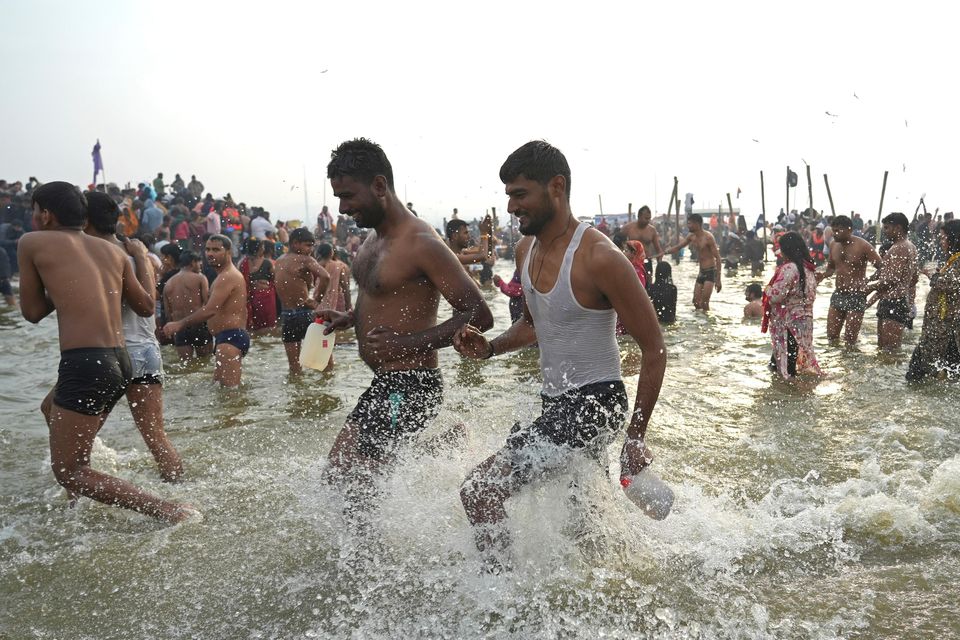 Hindu devotees take a holy dip in the Sangam in a bid to cleanse past sins (AP)