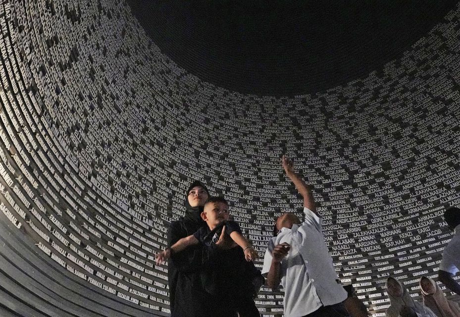 Visitors looks at a wall displaying the names of the victims of 2004 Indian Ocean tsunami, at the Tsunami Museum in Banda Aceh (Achmad Ibrahim/AP)