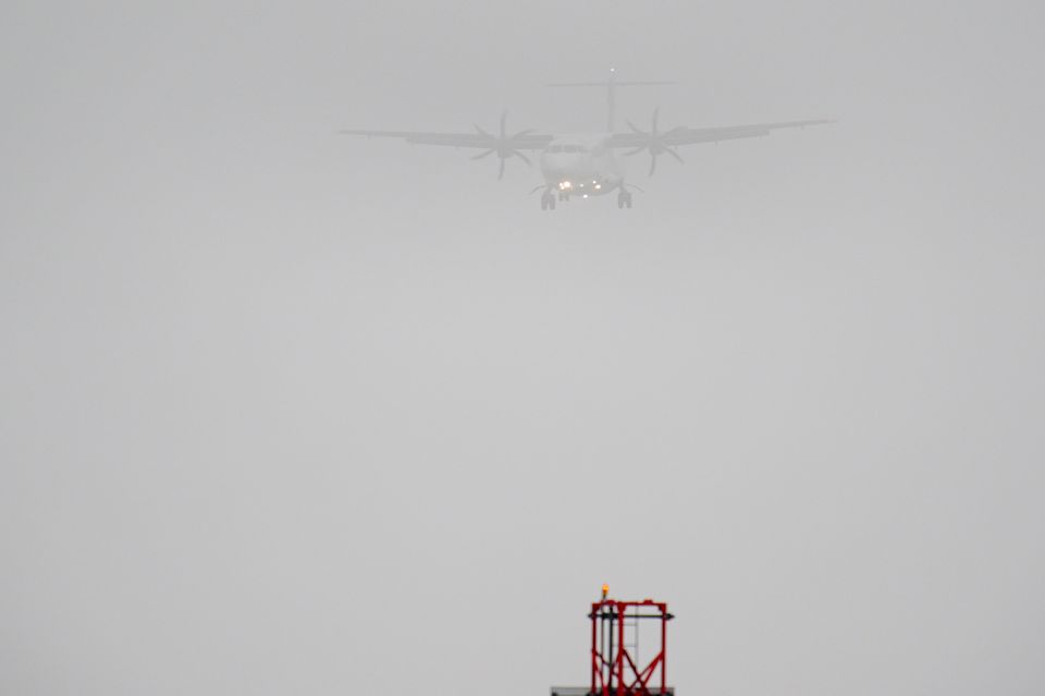 A plane lands in the mist at Cardiff Airport (Ben Birchall/PA)