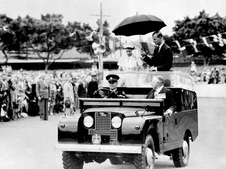 Queen Elizabeth II and the Duke of Edinburgh driving around Newcastle, Australia, in the very first State Review Land Rover vehicle, featuring a custom-designed rear platform which accompanied them on a six-month tour of the Commonwealth.