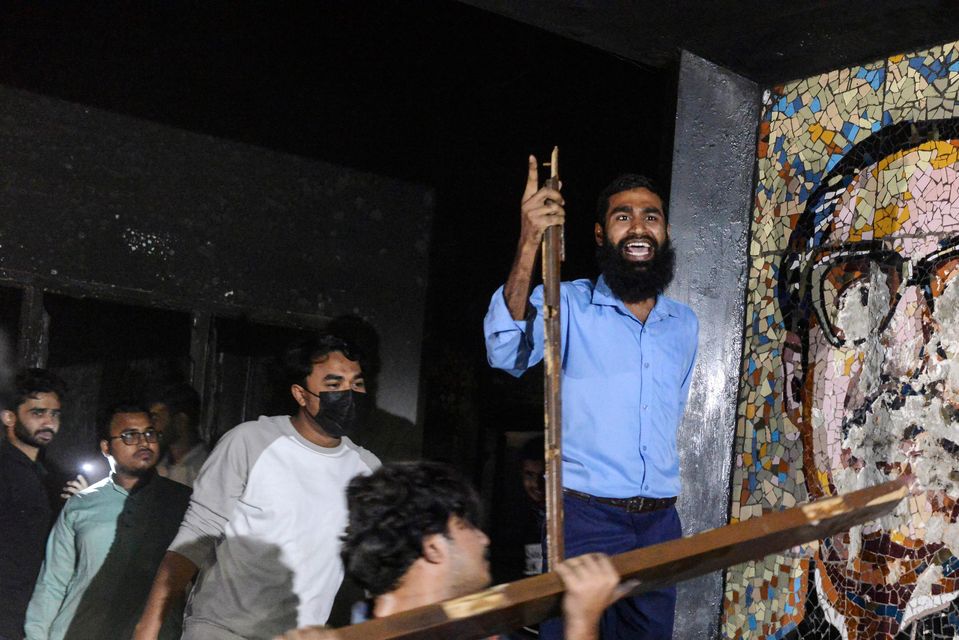 Protesters vandalise a portrait of Sheikh Mujibur Rahman at his residence at Dhanmondi, Dhaka (Mahmud Hossain Opu/AP)