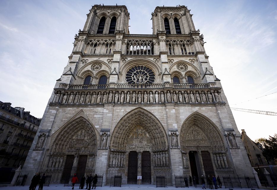 People stand outside Notre Dame cathedral in Paris (Sarah Meyssonnier/Pool Photo via AP)