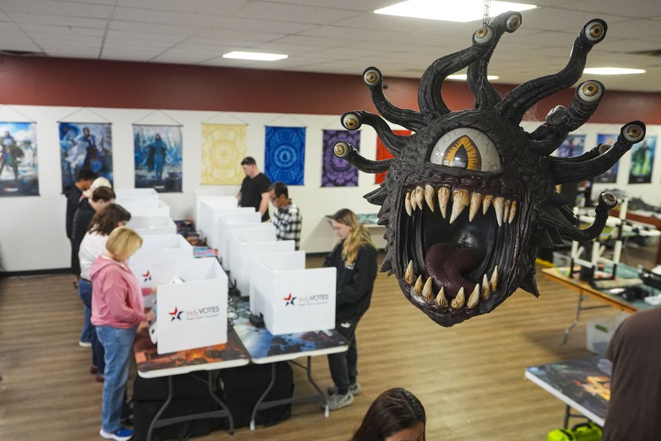 Beholder, a fictional monster in the Dungeons & Dragons fantasy role-playing game, hangs over a voting site as voters cast their ballots on Election Day at The Game Preserve store in Indianapolis (Michael Conroy/AP)