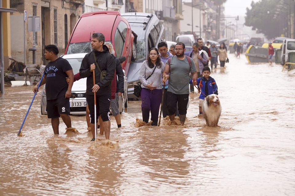 People walk through flooded streets in Valencia (Alberto Saiz/AP)