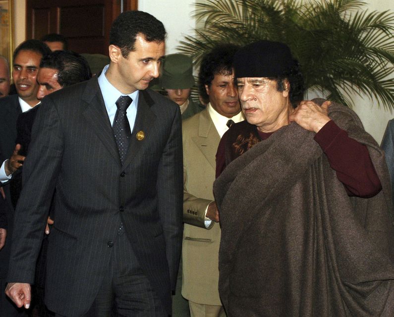 Bashar Assad with then Libyan leader Muammar Gaddafi at the League of Arab States summit in Algiers in 2005 (Nabil/AP)