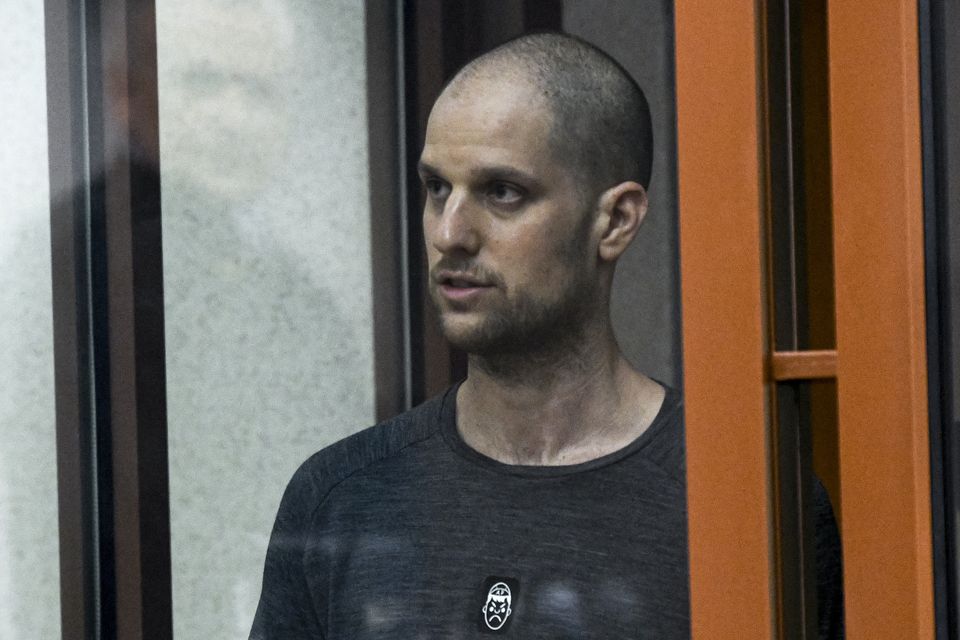 Evan Gershkovich stands listening to the verdict in a glass cage (AP)